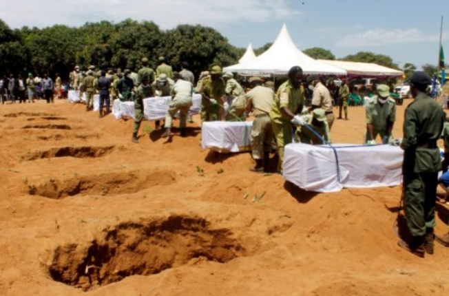 Coffins for victims of Tanzania ferry disaster being lowered into the grave.