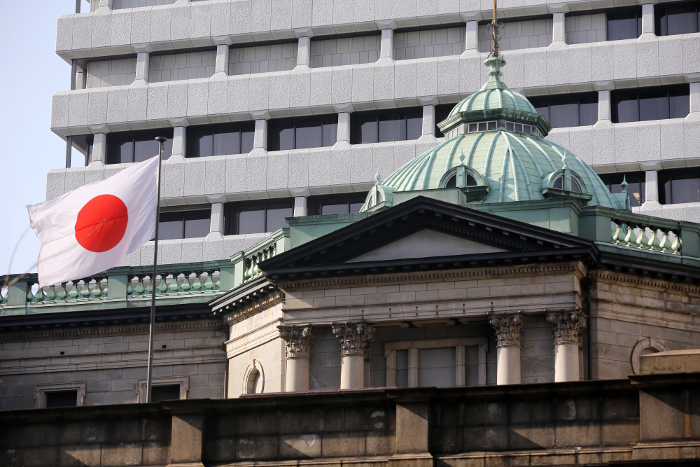 A Japanese flag flies atop the Bank of Japan (BOJ) headquarters in Tokyo, Japan